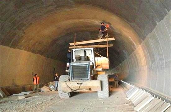 隨著我國(guó)公路建設(shè)規(guī)模的日益擴(kuò)大，公路隧道建設(shè)取得了很大的發(fā)展,公路隧道具有斷面大，地質(zhì)條件和施工技術(shù)復(fù)雜等特點(diǎn)，加之設(shè)計(jì)時(shí)對(duì)地質(zhì)條件的認(rèn)識(shí)不夠全面準(zhǔn)確，通車后存在的隧道老化、運(yùn)營(yíng)管理和維護(hù)等方面的原因，致使我國(guó)公路隧道的病害問(wèn)題十分嚴(yán)重，隧道襯砌背后的空洞問(wèn)題就是其一，由此引起的拱頂上鼓及襯砌內(nèi)緣壓裂、掉塊的現(xiàn)象嚴(yán)重影響到公路隧道的使用壽命。因此加強(qiáng)對(duì)隧道襯砌背后空洞的檢測(cè)判斷和處理，是隧道工程病害處理的重要一環(huán)。 一、檢查目的和必要性 目的：隧道拱部襯砌出現(xiàn)空洞剝落掉塊直接危及行車安全，但襯砌內(nèi)部病害隱蔽，無(wú)法通過(guò)肉眼發(fā)現(xiàn)，通過(guò)人工敲擊可有效發(fā)現(xiàn)襯砌內(nèi)部空洞等隱患，并對(duì)無(wú)損檢測(cè)資料有針對(duì)性的進(jìn)行驗(yàn)證。 必要性：通過(guò)隧道找部襯砌人工敲擊檢查?？蓪?duì)大部分拱部病害及早發(fā)現(xiàn)并進(jìn)行整治，從而降低運(yùn)營(yíng)期間拱部襯砌剝落掉塊的風(fēng)險(xiǎn)。 二、檢查時(shí)機(jī)和范圍 1、檢查時(shí)機(jī) 隧道二次襯砌貫通后，接觸網(wǎng)安裝前為最佳檢查時(shí)機(jī)，接觸網(wǎng)安裝后通電前次之，通電后則須停電 。 2、接觸網(wǎng)安裝前、后敲擊檢查的區(qū)別 接觸網(wǎng)安裝前后，敲擊方法、車輛、工具基本相同。主要區(qū)別： （1）接觸網(wǎng)作業(yè)車檢查平臺(tái)，升起高度或檢查架搭設(shè)高度不同，接觸網(wǎng)安裝前接觸網(wǎng)作業(yè)車檢查平臺(tái)升起高度或檢查架搭設(shè)高度距拱頂3米左右，拱頂至拱腰均易于敲擊，接觸網(wǎng)安裝后接觸網(wǎng)作業(yè)車檢查平臺(tái)升起高度，或檢查架搭設(shè)高度距離拱頂至少4米。 （2）檢查槌長(zhǎng)度不同。接觸網(wǎng)安裝前檢查槌長(zhǎng)度為2米左右，接觸網(wǎng)安裝后檢查槌長(zhǎng)度為2.5米至4.6米。 3、檢查范圍 當(dāng)使用供電檢查車或軌道車平板上搭檢查架檢查時(shí)，從拱頂中心線至起拱線半幅為一次敲擊檢查范圍，當(dāng)使用檢查架檢查時(shí)，從線路左側(cè)起拱線至線路右側(cè)起拱線全幅為一次敲擊檢查范圍。 圖片描述(最多50字) 三、檢查前準(zhǔn)備工作 1、車輛：接觸網(wǎng)檢查車，平板車搭檢查架，在鋼軌或側(cè)溝蓋板上推進(jìn)檢查架，以雙線隧道，軌頂至拱頂9米為例，且檢查平臺(tái)距接觸網(wǎng)立柱等侵限物體保持10至20厘米間距。 （1）采用接觸網(wǎng)檢查車檢查無(wú)接觸網(wǎng)時(shí)，檢查平臺(tái)高度以距拱頂3米為宜，檢查平臺(tái)橫向放置，有接觸網(wǎng)時(shí)，檢查平臺(tái)高度以距拱頂5米為宜，檢查平臺(tái)縱向放置，需要時(shí)再旋轉(zhuǎn)到橫向位置。 （2）平板車搭檢查架，鋼軌上安裝檢查架或側(cè)向水溝蓋板和兩線間底板頂搭設(shè)檢查架，無(wú)接觸網(wǎng)時(shí)，檢查平臺(tái)高度以距拱頂距離3米為宜，檢查平臺(tái)橫向?qū)挾瓤蛇_(dá)9米，有接觸網(wǎng)時(shí)，檢查平臺(tái)高度距離拱頂4米為宜，兩線間平臺(tái)需下凹0.5米，檢查平臺(tái)橫向?qū)挾瓤蛇_(dá)9.5米。 圖片描述(最多50字) 2、工具：大型工具有：接觸網(wǎng)檢查車、軌道車（含平板車）、檢查架（根據(jù)凈空定制）；小型工具有：手提式強(qiáng)光手電筒、頭部礦燈、檢查槌（空心鋼管直徑30mm，一端焊接一根尖頭鋼筋一端焊接一根平頭鋼筋，長(zhǎng)度2至4.6米不等），卷尺、塞尺、鋼直尺、噴漆、桶裝油漆、漆桿（4.5米長(zhǎng)竹竿一端綁扎油漆刷）、檢查梯、對(duì)講機(jī)、照相機(jī)、手套、安全帶、安全帽、防護(hù)衣、護(hù)目鏡、口罩、記錄本、黑水筆等。 3、人員：作業(yè)小組由8人組成（使用接觸網(wǎng)檢查車或軌道車時(shí)需1人持對(duì)講機(jī)指揮車輛），檢查車分工為：3人持檢查槌（敲擊半幅拱頂線路正上方拱腰，線路側(cè)方拱腰至起拱線），2人聽(tīng)敲擊音并標(biāo)記，1人記錄并拍照，1人指揮并負(fù)責(zé)安全檢查和提示，檢查架分工為：4人持檢查槌敲擊拱頂、拱腰，2人聽(tīng)敲擊音標(biāo)記并負(fù)責(zé)指揮及安全檢查提示，2人記錄并拍照。 四、敲擊檢查程序 1、開(kāi)窗安排：提前一天申請(qǐng)檢查天窗，天窗時(shí)間本線封鎖不少于8小時(shí)，鄰線限速每小時(shí)20公里，根據(jù)批準(zhǔn)的天窗計(jì)劃，駐站聯(lián)絡(luò)員在《行車設(shè)備登記簿》內(nèi)登記，列車高度員下達(dá)調(diào)度命令；施工負(fù)責(zé)人接到調(diào)度命令后按調(diào)度命令憑證發(fā)車；檢查車到指定地點(diǎn)后，立即設(shè)置防護(hù)體系。在距離檢查地點(diǎn)20米處現(xiàn)場(chǎng)防護(hù)員設(shè)置移動(dòng)停車信號(hào)彈（燈），在距離施工地點(diǎn)800米兩端防護(hù)員設(shè)置顯示停車手信號(hào)；鄰線防護(hù)需設(shè)置移動(dòng)減速信號(hào)牌和減速地點(diǎn)標(biāo)。天窗作業(yè)計(jì)劃結(jié)束前機(jī)車返回申請(qǐng)停靠點(diǎn)。駐站聯(lián)絡(luò)員與現(xiàn)場(chǎng)防護(hù)員在執(zhí)行防護(hù)任務(wù)時(shí)，應(yīng)佩戴標(biāo)志攜帶通信設(shè)備，現(xiàn)場(chǎng)防護(hù)員還應(yīng)攜帶必要的防護(hù)用品；隨時(shí)掌握現(xiàn)場(chǎng)和列車運(yùn)行情況。發(fā)現(xiàn)異常情況及時(shí)通知車站值班員和施工負(fù)責(zé)人。駐站聯(lián)絡(luò)員應(yīng)與現(xiàn)場(chǎng)防護(hù)員時(shí)刻保持聯(lián)系。 圖片描述(最多50字) 2、敲擊作業(yè)：車輛行駛速度控制在每小時(shí)5公里以內(nèi)，檢查架推進(jìn)速度控制在每小時(shí)1公里以內(nèi)，行進(jìn)過(guò)程中進(jìn)行敲擊，憑敲擊聲音辨別是否存在空洞，聲音異常時(shí)停車仔細(xì)敲擊確認(rèn)空洞范圍，施工縫、混凝土修補(bǔ)、蜂窩、混凝土表面有雜物（如鋼筋頭、注漿管等）、施工冷縫、止水帶外露、防水板外露、閉環(huán)裂紋、變形外鼓等重點(diǎn)處所均停車進(jìn)行仔細(xì)敲擊檢查。 3、照明配置、照度、范圍：BAD305手提式防爆探照燈2臺(tái)，BAD212微型手持防爆調(diào)光工作燈2臺(tái)，LED722B充電頭燈2臺(tái)，照度不低于250勒克斯，照明可視距度10m。 4、敲擊人員自我防護(hù)注意事項(xiàng)：（1）作業(yè)前將勞動(dòng)防護(hù)用品穿戴整齊‘（2）攀爬腳手架時(shí)，要站穩(wěn)扶牢。登上檢查平臺(tái)后，須首先掛好安全帶和安裝欄桿扶手，工具應(yīng)放置穩(wěn)固。（3）接觸網(wǎng)檢查車檢查平臺(tái)、檢查架移動(dòng)前應(yīng)通知作業(yè)人員停止作業(yè)，將工具擺放穩(wěn)固，人員蹲下扶牢，目視前進(jìn)方向，機(jī)車指揮人員發(fā)現(xiàn)侵限物體要及時(shí)停車，拆除侵限物體。檢查架移動(dòng)就位后，必須設(shè)好滾輪制動(dòng)和斜撐后，方可作業(yè)。（4）檢查小組人員必須團(tuán)結(jié)協(xié)作、聽(tīng)從指揮，相互提醒安全注意事項(xiàng)，做到自控、互控。（5）人員站位要相對(duì)固定，避免檢查槌等工具碰傷人員。（6）清除襯砌掉塊時(shí)，應(yīng)高聲提醒所有人員注意安全，下方無(wú)人時(shí)，方可進(jìn)行作業(yè)。（7）鄰線來(lái)車時(shí)，須停止作業(yè)，小穩(wěn)扶牢，檢查工具不得侵限。 5、檢查架的組成：同槽鋼跑道、腳手架滾輪及抽動(dòng)裝置、 鋼管立柱、鋼管橫撐、鋼管斜撐、十字卡、萬(wàn)向卡、腳手板及鐵絲、欄桿及鎖口鋼筋、反光標(biāo)等組成。 6、缺陷確認(rèn)：敲擊聲音清脆，發(fā)出“鐺、鐺、鐺”的聲音說(shuō)明襯砌混凝土比較密實(shí)，如果敲擊聲音沉悶出現(xiàn)“咚、咚、咚”的聲音，說(shuō)明襯砌混凝土存在空洞，附帶檢查內(nèi)容包括襯砌掉塊、裂紋、滲漏水、露筋、鋼筋保護(hù)層厚度不足、蜂窩麻面、混凝土夾帶雜物等。 7、問(wèn)題標(biāo)記：發(fā)現(xiàn)問(wèn)題停車采用紅油漆標(biāo)記問(wèn)題范圍，測(cè)量（估算）相關(guān)尺寸，將病害類型、尺寸等數(shù)據(jù)詳細(xì)記錄、拍照存檔，如在空洞外邊界標(biāo)記面積范圍，在裂縫起終點(diǎn)位置用箭頭（箭頭朝向裂紋處）標(biāo)記長(zhǎng)度，箭頭旁標(biāo)出裂紋寬度值，同時(shí)將問(wèn)題類型、編號(hào)、里程用紅油漆在問(wèn)題位置邊墻上進(jìn)行標(biāo)記，以便日后整改。標(biāo)記形式“BLWKD-1-K493+179”，BLW指白力塢隧道，KD指拱部空洞，1指編號(hào)為1號(hào)，K493+179指空洞里程，若一個(gè)隧道有多處空洞，序號(hào)按里程從小到大排序，依次為1、2、3、4.......。 8、資料整理：為避免出現(xiàn)場(chǎng)檢查發(fā)現(xiàn)問(wèn)題記憶模糊、相似問(wèn)題相互混淆的情況，檢查小組每天須將當(dāng)天檢查發(fā)現(xiàn)的問(wèn)題，根據(jù)病害類型、部位、按靜態(tài)驗(yàn)收?qǐng)?bào)告格式進(jìn)行梳理、統(tǒng)計(jì)，將照片編輯相應(yīng)文字說(shuō)明。